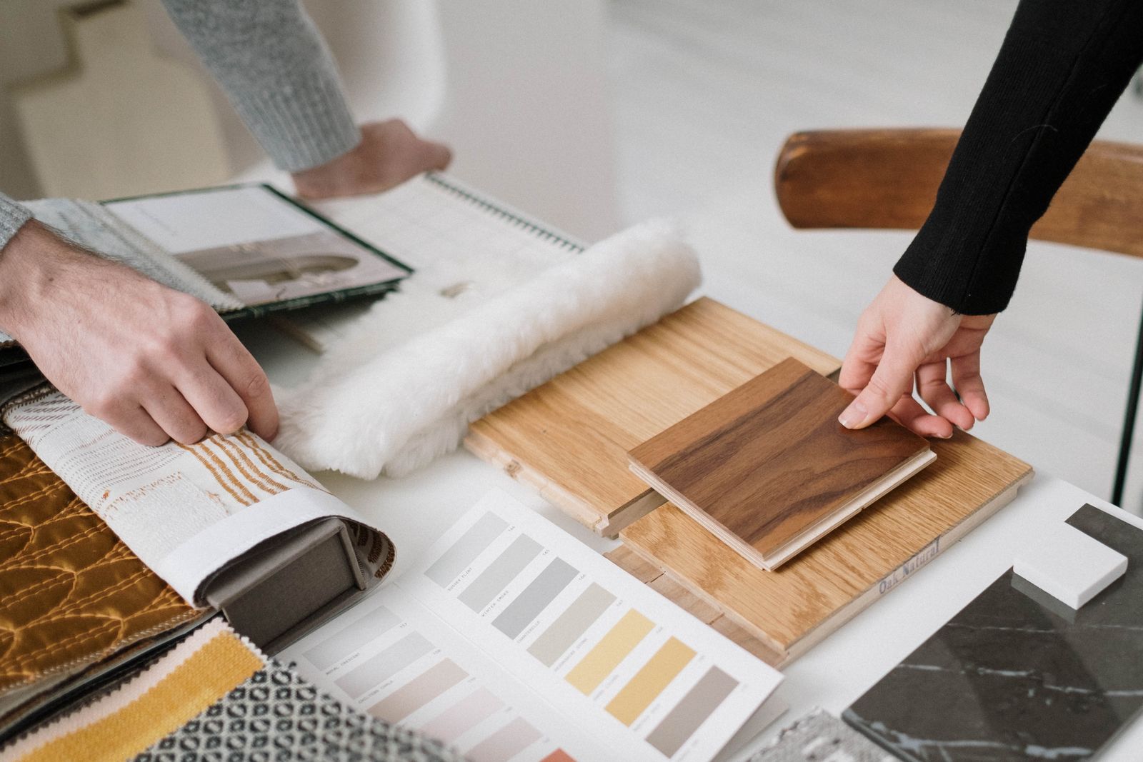 Client briefing: comparing wood veneer, fabric swatches, paint charts and stone samples across the table